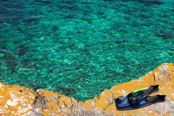 Máscara, snorkel y aletas en el acantilado del mar —  Fotos de Stock