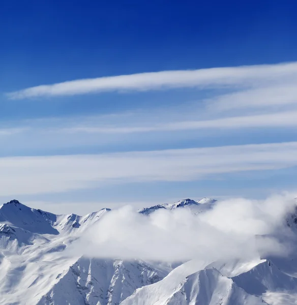 Snow mountains in clouds at sun day — Stock Photo, Image