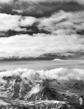 Black and white sunlight snowy mountains in clouds clipart