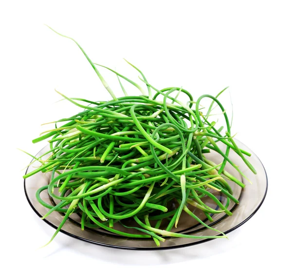 Fresh garlic scapes on glass plate — Stock Photo, Image