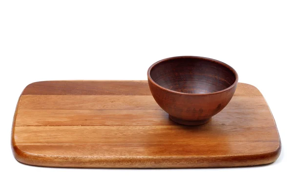 Empty ceramic bowl on wooden kitchen board — Stock Photo, Image