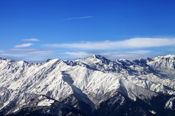 Montañas nevadas y un cielo azul con nubes en un día soleado agradable —  Fotos de Stock