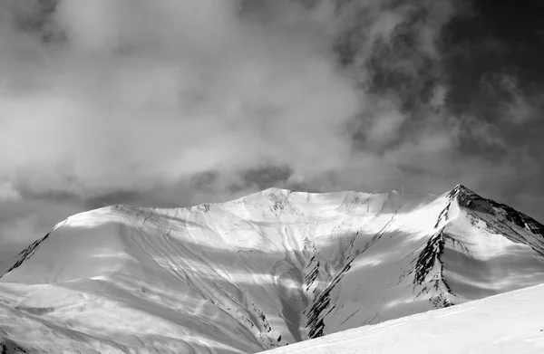 Vista de preto e branco em declive nevado fora de pista, em dia de vento — Fotografia de Stock