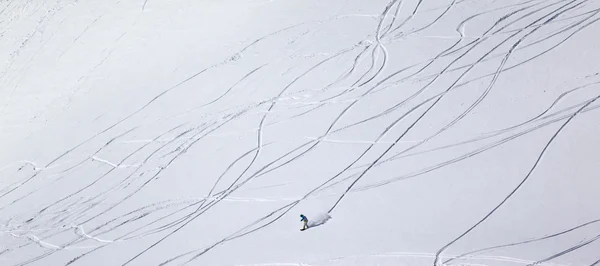 Vista panorámica de snowboarder cuesta abajo en la pendiente de la pista con n —  Fotos de Stock
