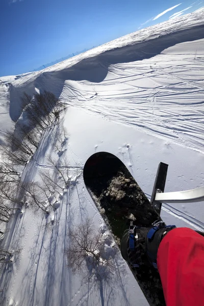 Snowboard over off-piste helling in zon-dag — Stockfoto