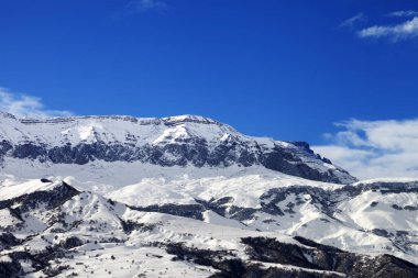 Snowy mountains and blue sky at nice sun winter day. Greater Caucasus, Mount Shahdagh, Azerbaijan. 