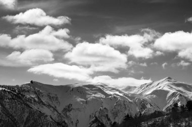 Güneş ışığı karlı dağlarda ve bulutlu gökyüzünde siyah beyaz manzara. Kafkas Dağları. Gürcistan 'ın Svaneti bölgesi.