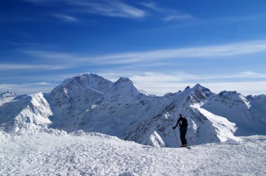 Kayakçı pist dışı inişe başlamadan önce. Karlı kışta Kafkas Dağları. Yamaçtan Donguzorun Dağı 'na bak. Elbrus..