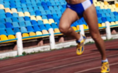 Stadyumdaki bulanık atletizm koşu yarışması odak noktasında değil. Arkaplan olarak kullan.