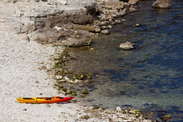 夏の日に海の海岸の小石のビーチでオレンジカヤック — ストック写真