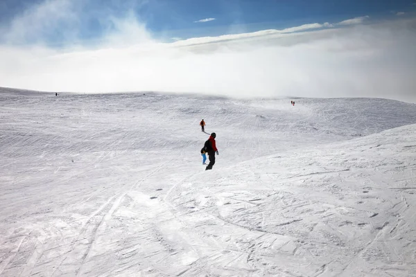 Kayakçılar Snowboardcular Kar Yamacında Gökyüzünde Güneş Işığı Bulutlarıyla Kış Gününde — Stok fotoğraf