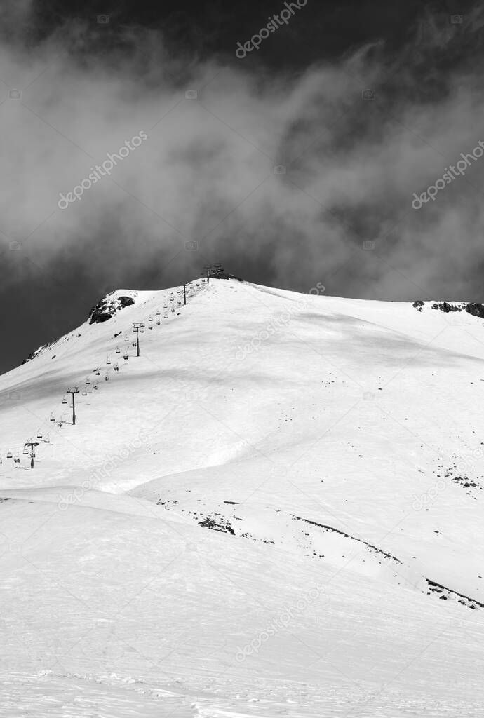 Black and white view on ski resort and chair-lift at sunny winter day. Caucasus Mountains. Georgia, Gudauri, Mount Kudebi.
