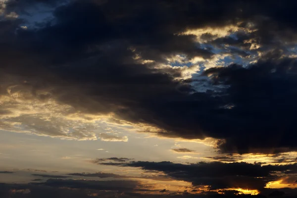 Nubes oscuras y cielo del amanecer con sol y rayos — Foto de Stock