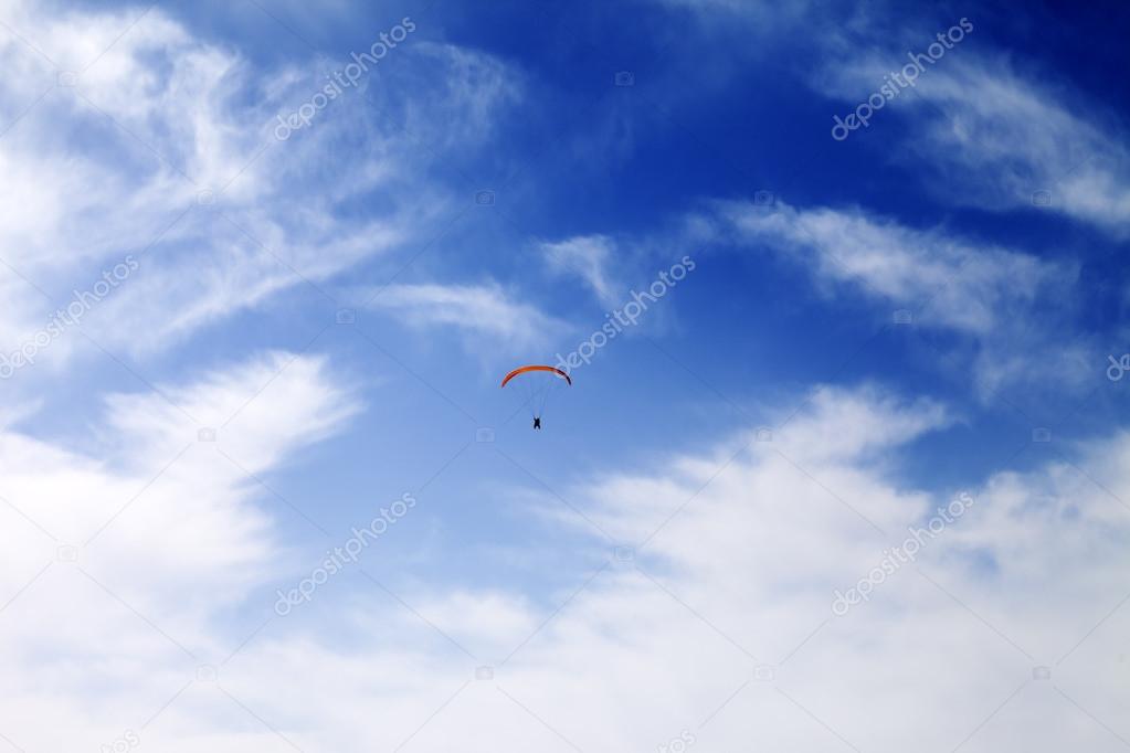 Silhouette of skydiver at sky