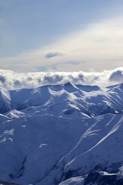 Snowy mountains and sunlight clouds at evening — Stock Photo, Image