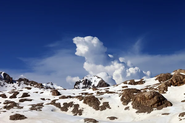 Güzel bir gün bulutlu gökyüzü ve karlı kaya — Stok fotoğraf