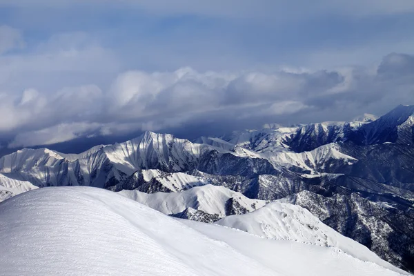 ゲレンデ外の雪が多い斜面およびクラウドの山 — ストック写真
