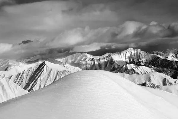 Pendiente de nieve fuera blanco y negro y las montañas nubladas —  Fotos de Stock