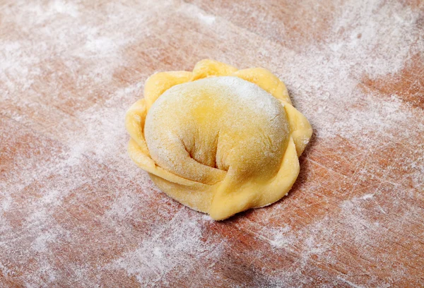 Raw ravioli on wooden cutting board — Stock Photo, Image