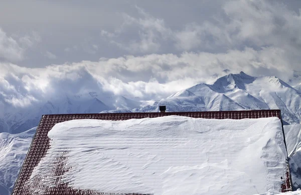 Tetto innevato e montagne nelle nubi — Foto Stock