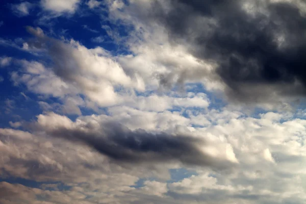 Blauer Himmel mit Sonne und dunkle Wolken — Stockfoto