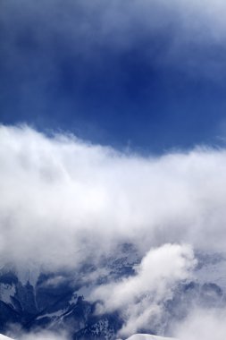 Güneş gün bulutlara karlı dağlarda