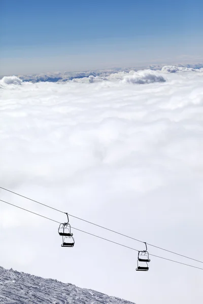 Skipiste, stoeltjeslift en bergen onder wolken — Stockfoto