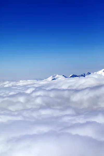 Bergen onder wolken en heldere blauwe hemel — Stockfoto