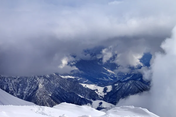 Top view on winter snowy mountains in clouds - Stock-foto