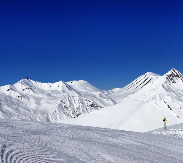 Pista de esqui e sinal de aviso — Fotografia de Stock