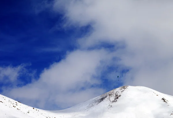 Paraglider sagoma delle montagne in cielo ventoso — Foto Stock