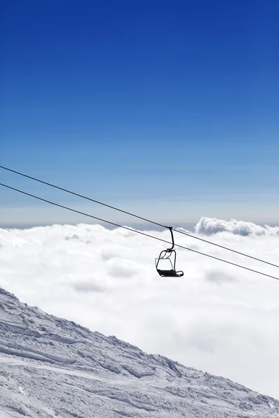 Pista de esquí, elevación de la silla y montañas bajo nubes — Foto de Stock