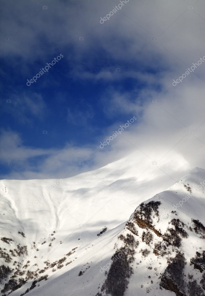 View on off-piste sunlight slope in clouds