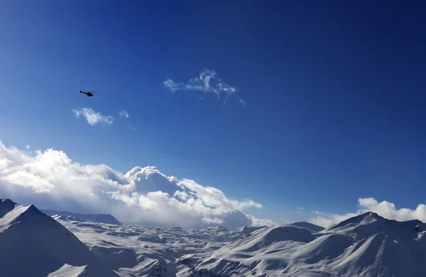 Elicottero sopra altopiano innevato e cielo pieno di sole — Foto Stock