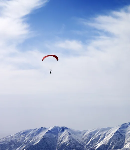 Paraglider silhouette of mountains in windy sky at sun day — Stock Photo, Image