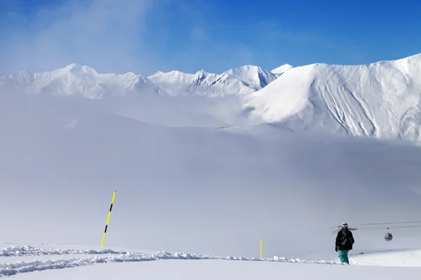 Snowboarder en pendiente fuera de pista y montañas en la niebla — Foto de Stock