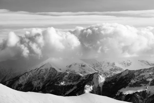 Schwarz und weiß verschneite Berge in Wolken und Off-Piste-Hang — Stockfoto