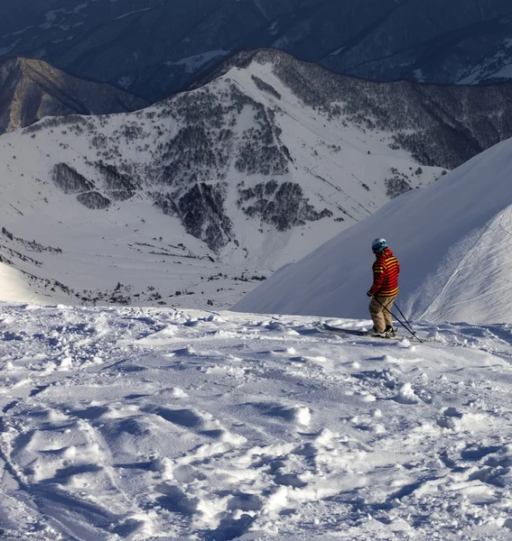 Esquiador em inclinação fora de pista em tarde ensolarada — Fotografia de Stock