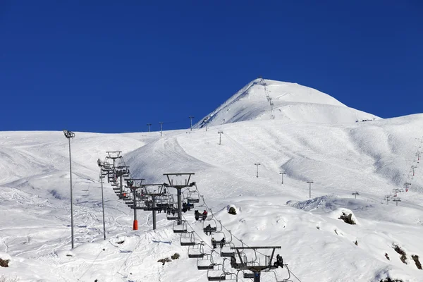 Montañas de invierno y pista de esquí en el día de buen sol —  Fotos de Stock