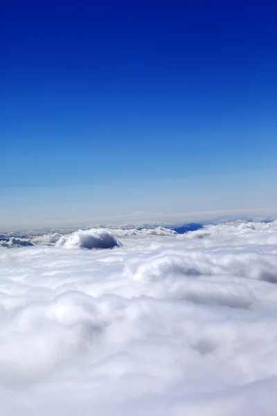Bergen onder wolken en heldere blauwe hemel — Stockfoto