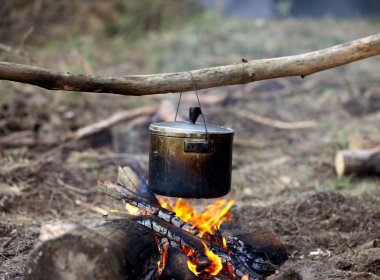 Kamp ateşinde ıslak kazanda yemek pişirmek 