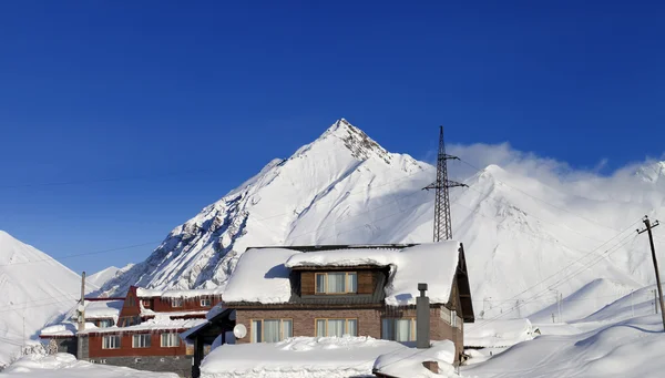 Alberghi in montagne di inverno nevoso al giorno del sole — Foto Stock
