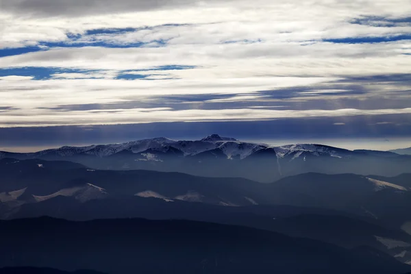 Silhouetten van bewolkt bergen in avond — Stockfoto