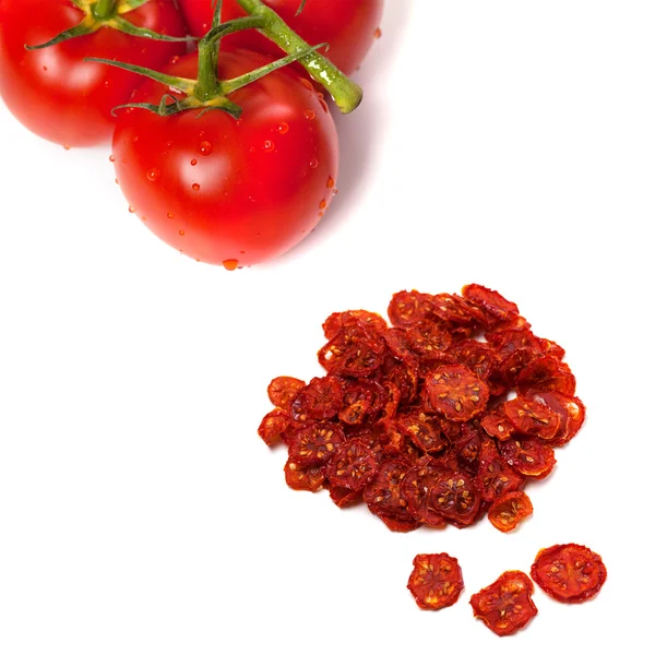 Tomate maduro com gotas de água e secas fatias de tomate — Fotografia de Stock