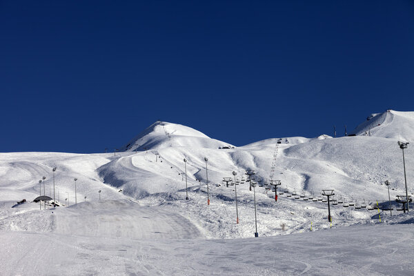 Winter mountains and ski slope at sun day