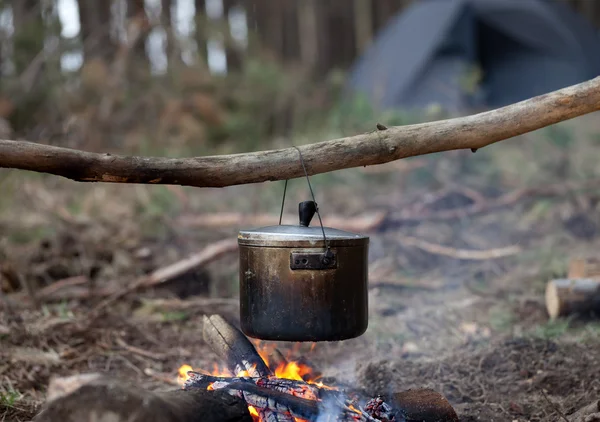 Cozinhar em caldeirão de fuligem na fogueira — Fotografia de Stock