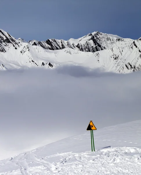 Avviso cantare sulla pista da sci e le montagne nella nebbia — Foto Stock