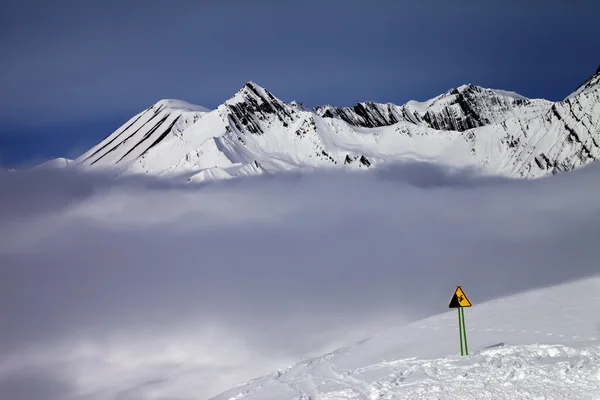 Warnung singen auf Skipiste und Berge im Nebel — Stockfoto