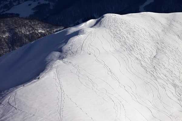 Boven uitzicht op uit piste helling met snowboarders en skiërs in zelfs — Stockfoto