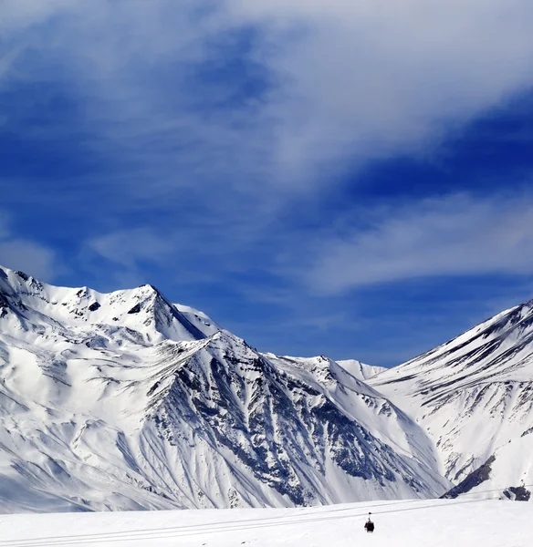 Montañas de invierno y un cielo azul con nubes — Foto de Stock